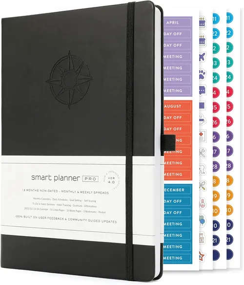 Black hardcover smart planner notebook beside colour-coded monthly sticker sheets