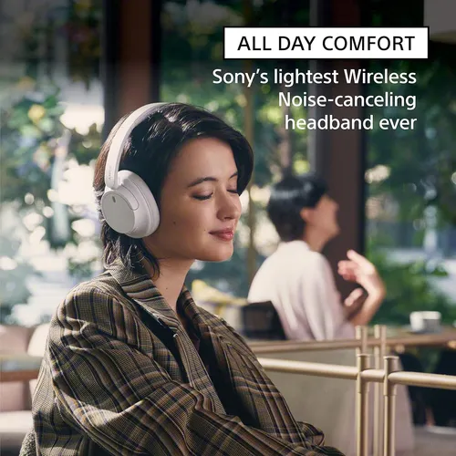 Woman wearing Sony white wireless noise-cancelling headphones in a cafe